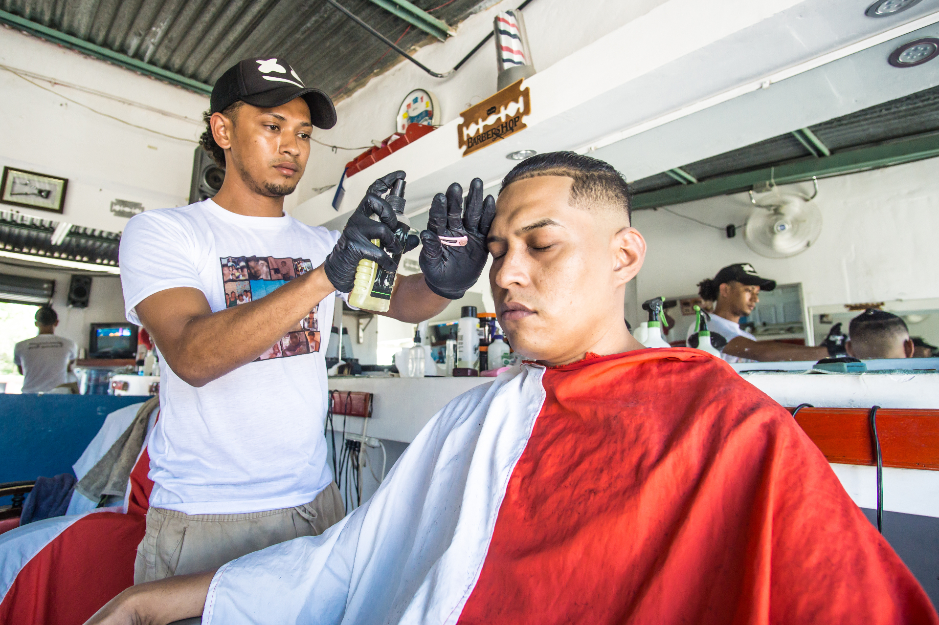 Barbero latino atendiendo a un cliente